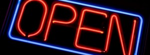 A neon OPEN sign glowing red in the window of a store